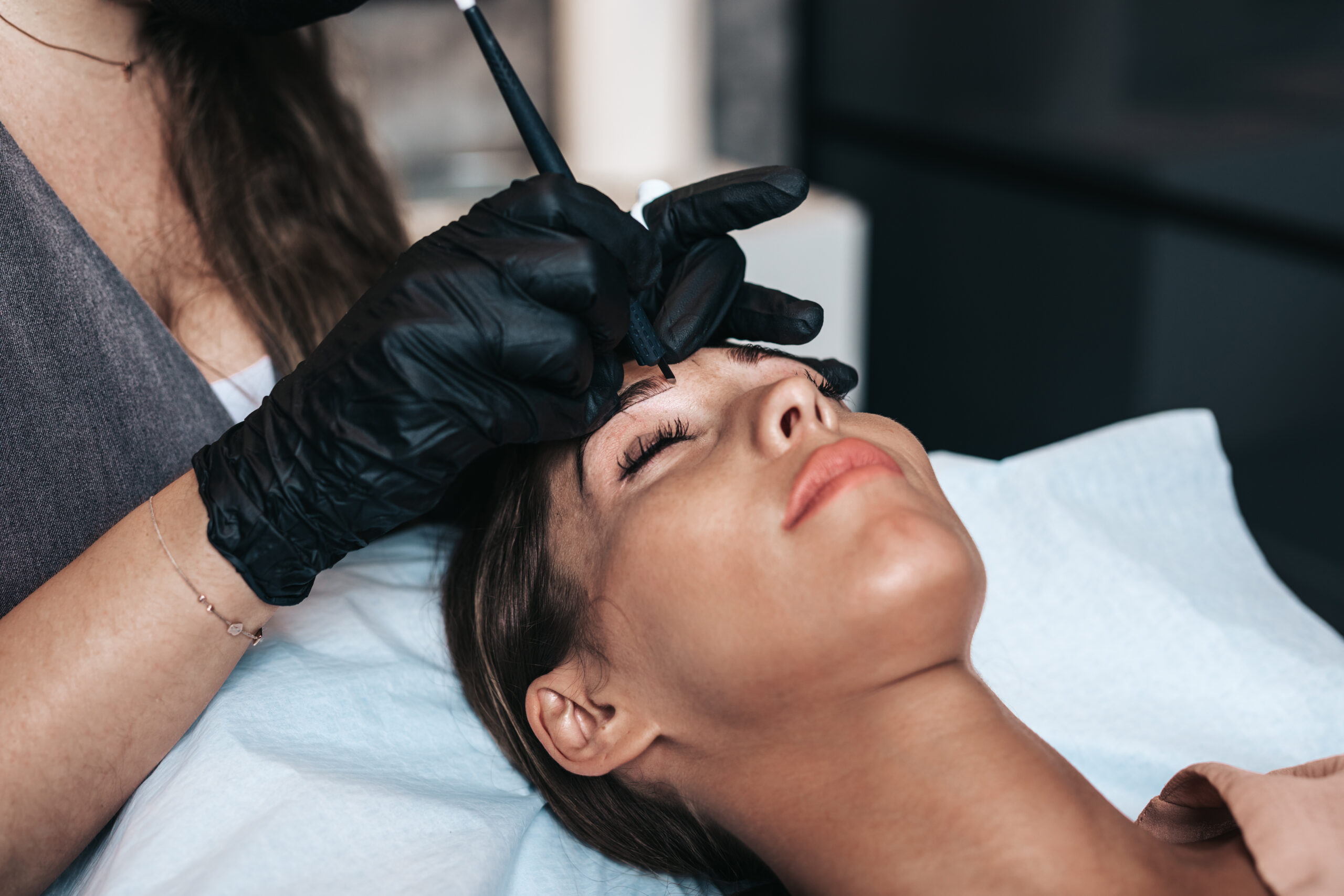 Permanent make-up for eyebrows of beautiful young woman in beaut